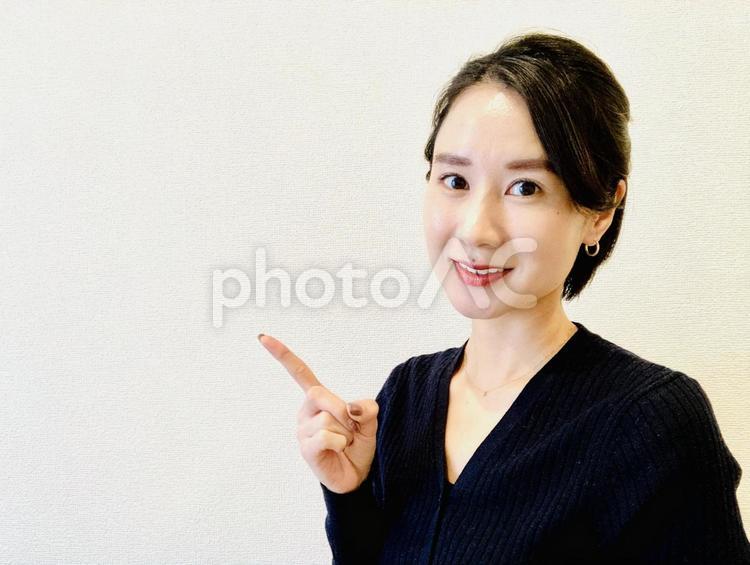 笑顔で指をさす日本人女性 ビジネス,ポイント,ナンバーワンの写真素材
