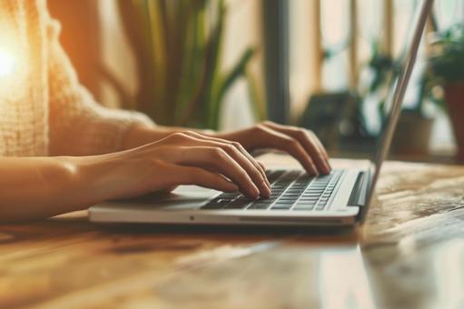 ノートパソコンでのタイピング作業の写真