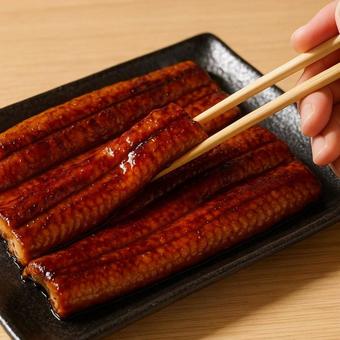 箸で持つうなぎの蒲焼き・土用の丑の日 箸で持つうなぎの蒲焼き・土用の丑の日の写真