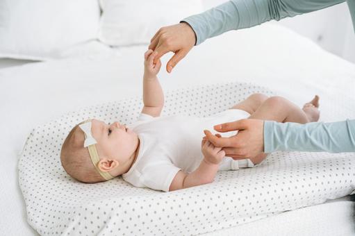 握った指を見つめる仰向けの赤ちゃん 握った指を見つめる仰向けの赤ちゃんの写真