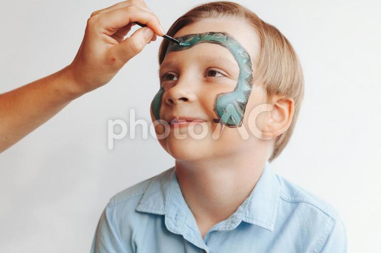 顔にヘビを描いてもらっている男の子 男の子,フェイスペイント,アートの写真素材