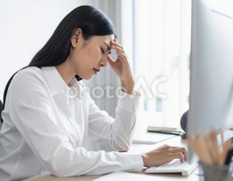 パソコンの前で頭を抱える女性 ビジネス,ノートパソコン,パソコンの写真素材