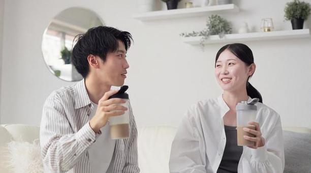 リビングでプロテインを飲むアジア人の男女 プロテイン,飲む,男性の写真素材