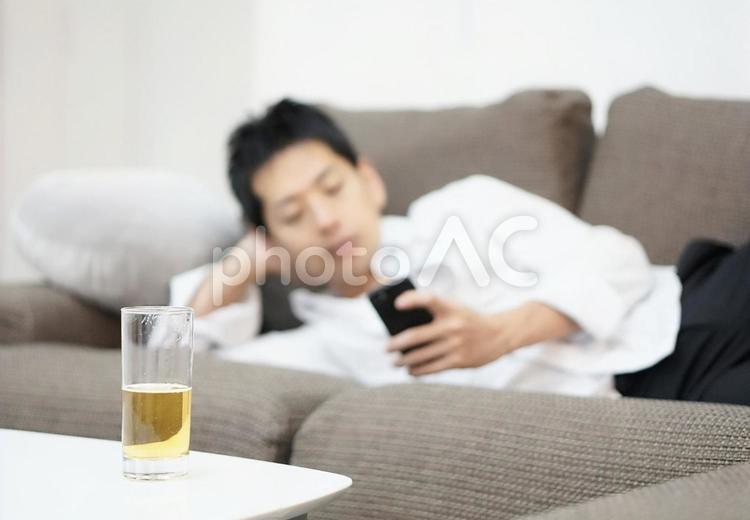 だらしなくスマホを触る男性 だらしない,グダグダ,やる気なしの写真素材