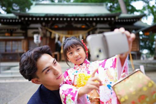 笑顔でスマホを構える女の子 笑顔でスマホを構える女の子の写真