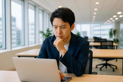 開放的なオフィスで考える男性 開放的なオフィスで考える男性の写真