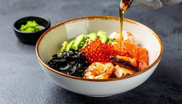 海鮮丼に醤油をかけるの写真