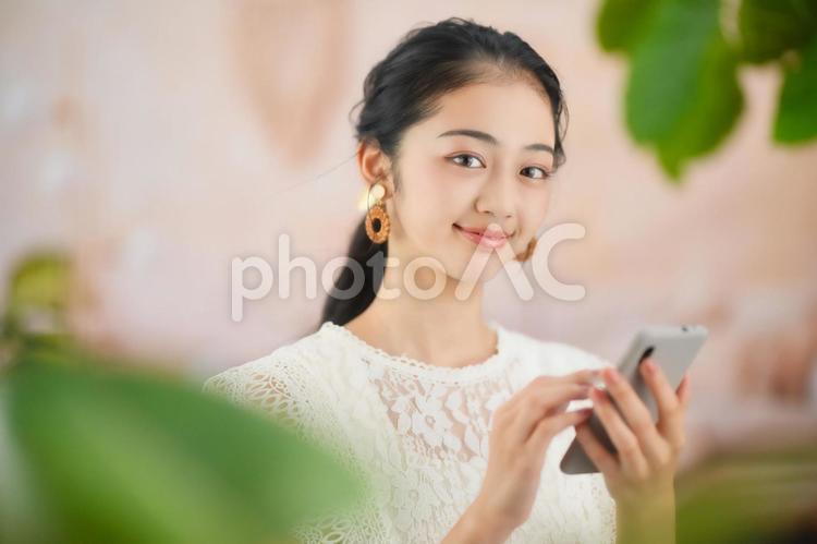 スマホを持ちカメラ目線の女性 女性,スマホ,持つの写真素材