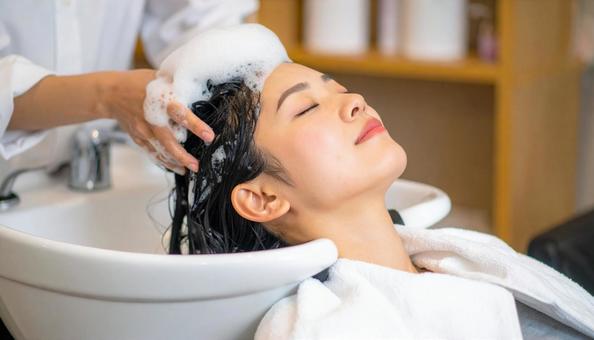 美容室でシャンプーしてもらう女性の写真