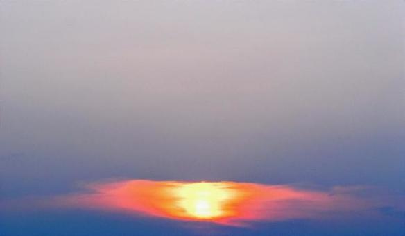 雲の向こうから照らす夕陽と暮れる空 雲の向こうから照らす夕陽と暮れる空の写真