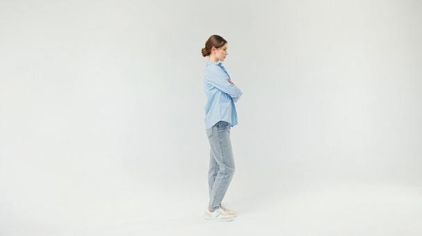腕組みをして立つ横向き女性 腕組みをして立つ横向き女性の写真