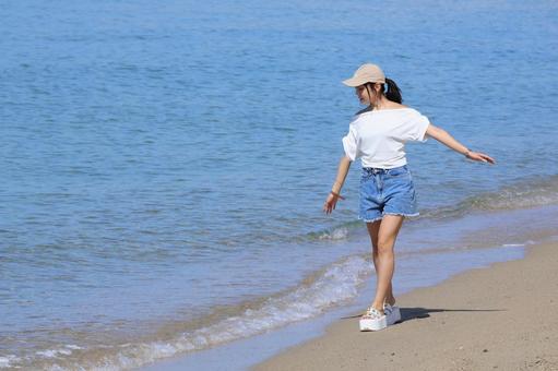 波打ち際を歩く女性 波打ち際を歩く女性 女性,コピースペース,海の写真素材