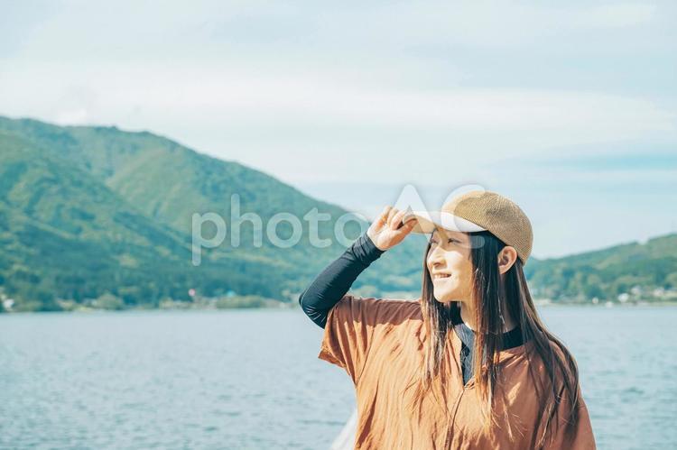 湖の桟橋に立つ女性キャンパーの横顔 アウトドア,帽子,女性の写真素材