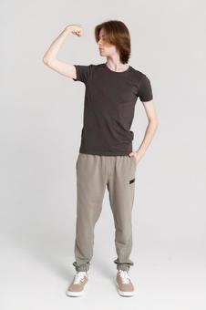 力こぶを見る長髪男性 力こぶを見る長髪男性の写真