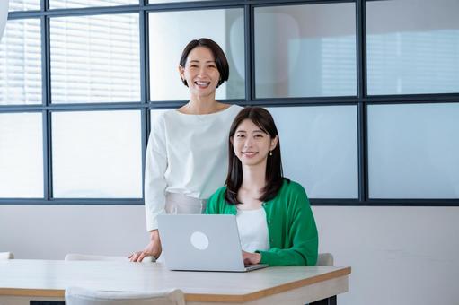窓のある部屋でパソコンを見る女性二人 窓のある部屋でパソコンを見る女性二人 会議,教える,女性の写真素材