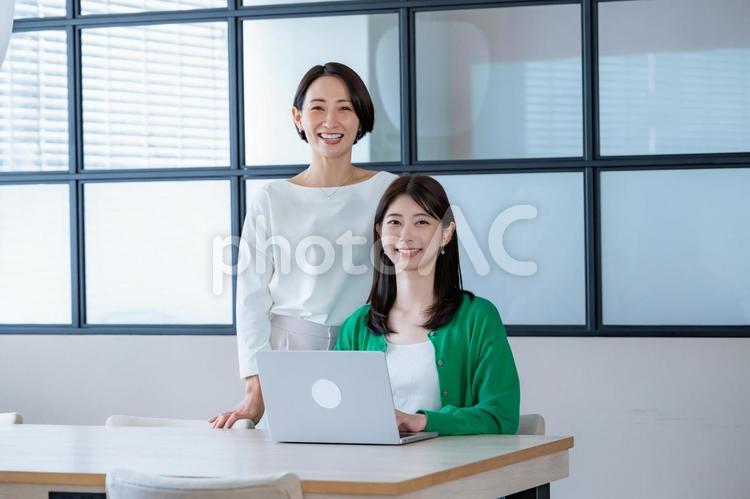 窓のある部屋でパソコンを見る女性二人 会議,教える,女性の写真素材