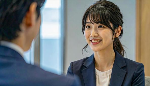 笑顔で話すスーツ姿の女性の写真