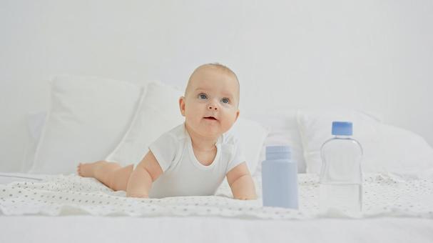 ベッドの上で見上げる赤ちゃん ベッドの上で見上げる赤ちゃんの写真