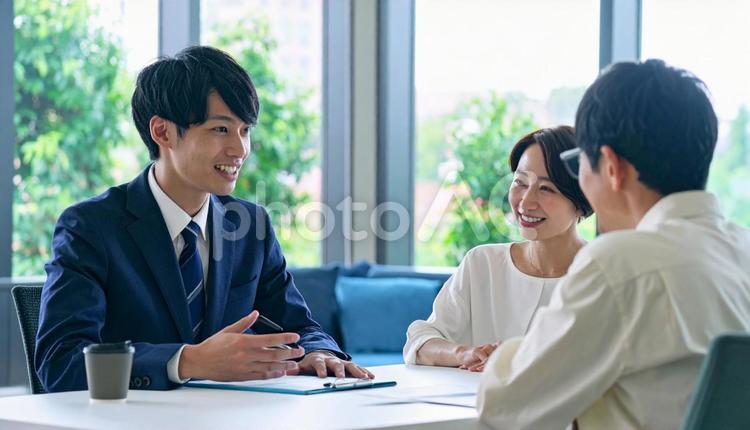 男性営業マンの説明を聞く夫婦 男性,営業マン,説明の写真素材