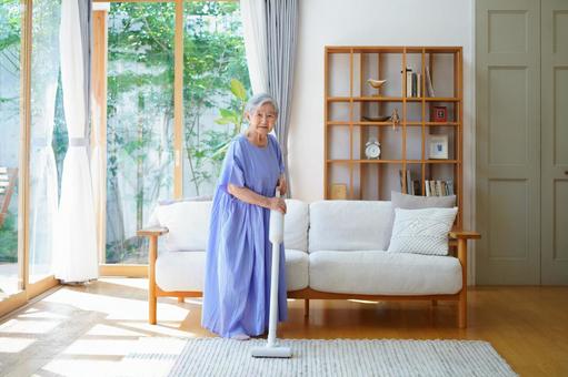 白い掃除機を持ち微笑み立つ女性 女性,掃除,掃除機の写真素材