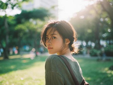 公園を一人で歩く女性 公園を一人で歩く女性の写真