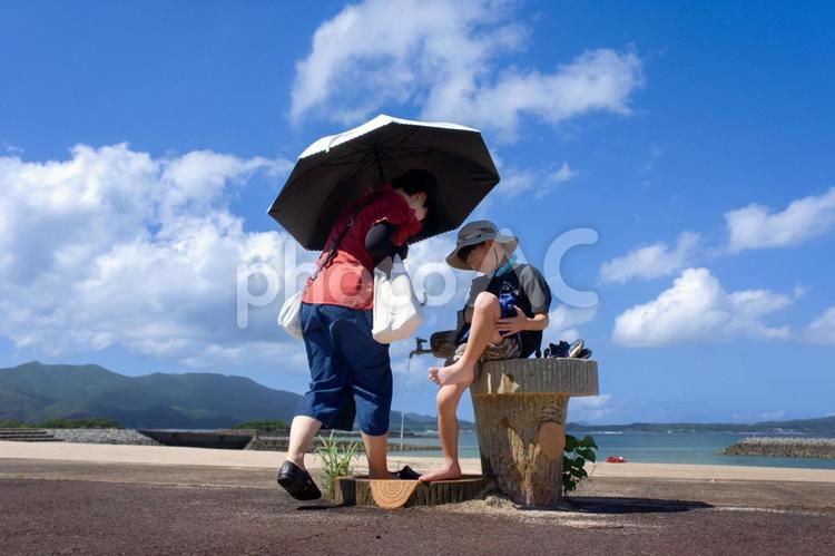 ＜素材＞夏の海水浴場で足を洗う親子・母子 女性,子供,男性の写真素材