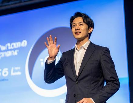 ステージ上で堂々とプレゼンする男性 ステージ上で堂々とプレゼンする男性の写真