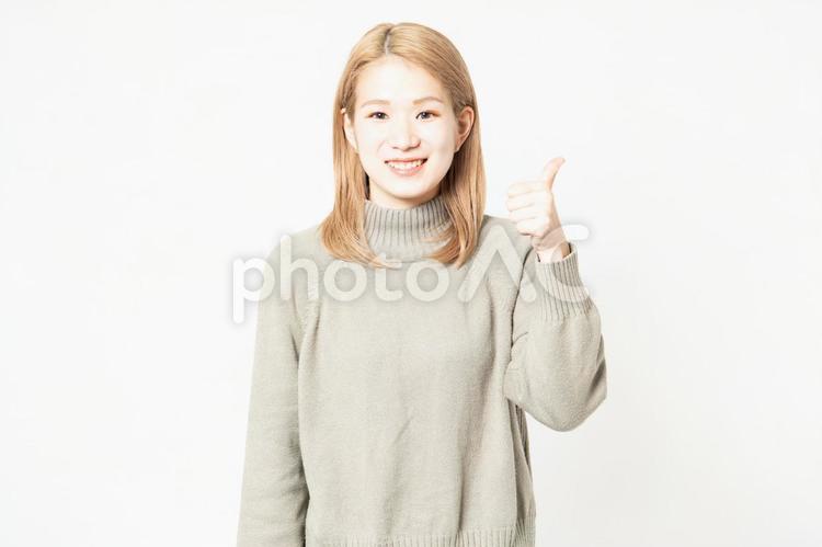 いいねのポーズをするセーターを着た若い女性 いいね,親指,女性の写真素材