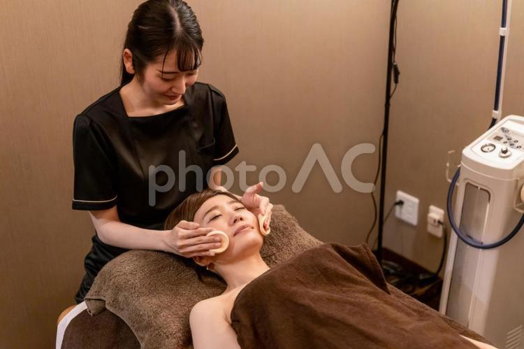 エステサロンで施術を受ける女性（拭き取り） フェイシャルエステ,エステサロン,スキンケアの写真素材