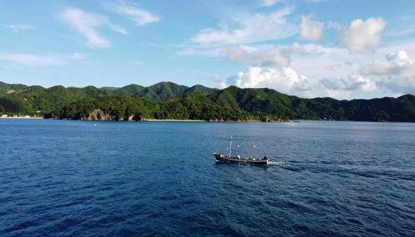 夏の青い海に浮かぶ船と青空 夏の青い海に浮かぶ船と青空の写真
