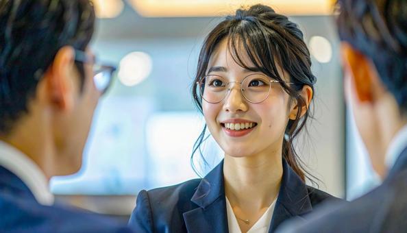 笑顔で話すスーツ姿の女性の写真