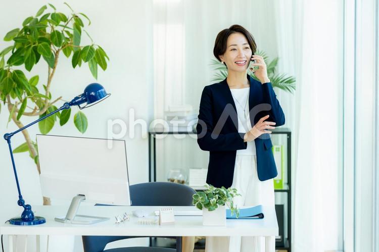 オフィスでスマホを使うビジネスウーマン スマホ,ビジネスウーマン,通話の写真素材