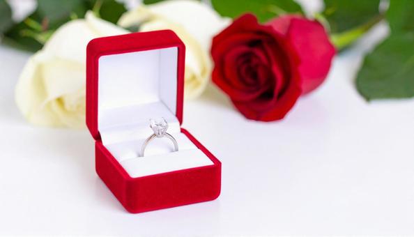 赤いバラのフラワーボックスと婚約指輪の写真