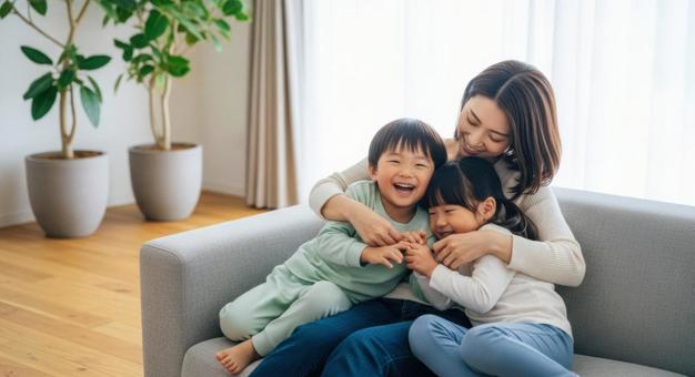 ソファで親子が笑顔で寄り添う幸せな時間 ソファで親子が笑顔で寄り添う幸せな時間の写真