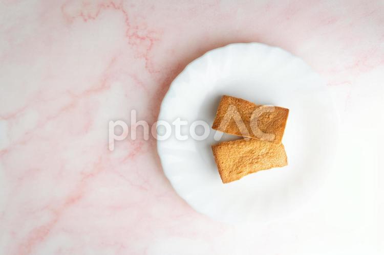 白皿と焼き菓子と桜色背景⑤ フィナンシェ,焼き菓子,スイーツの写真素材