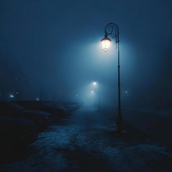 霧の夜道を手探りで進む光の写真