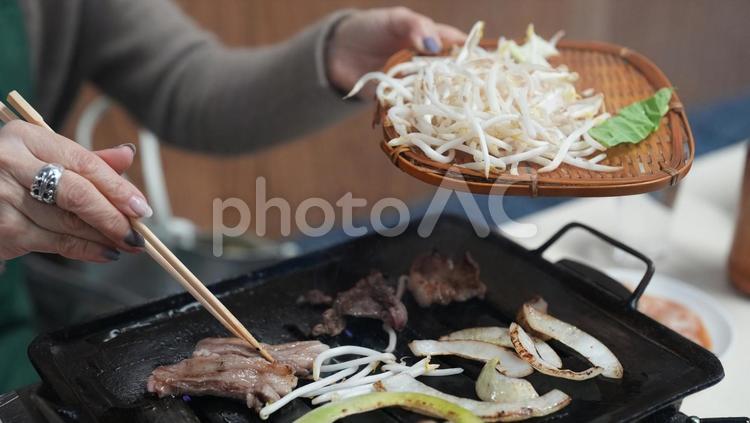 野菜と肉を焼く女性 女性,食事中,焼き肉屋の写真素材