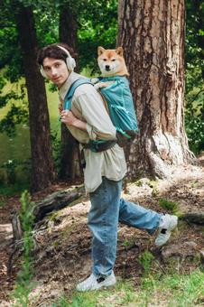 森の中で犬を背負う男性の写真