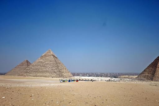The three pyramids of Giza towering under the blue sky, JPG