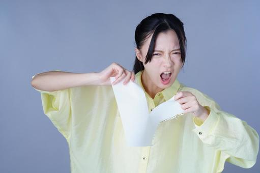 紙を破る黄色い服の女性 女性,紙,ルーズリーフの写真素材