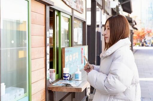 食べ歩きを楽しむ女性 食べ歩き,女性,支払いの写真素材