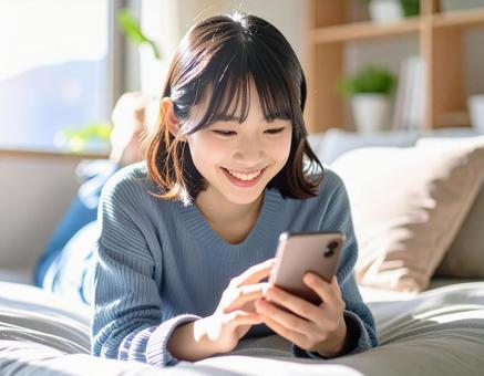 ソファでスマホを見る女性4 ソファでスマホを見る女性4の写真