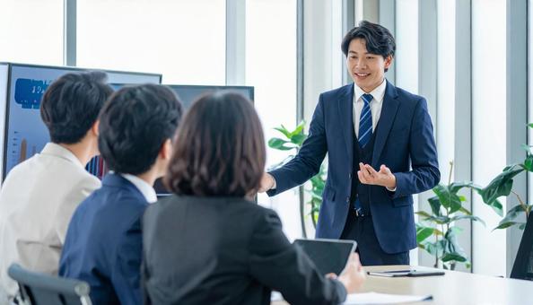 対面で説明する日本人男性ビジネスマン 対面で説明する日本人男性ビジネスマンの写真