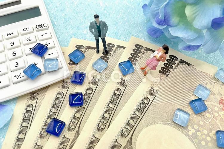 お金とカップルと電卓　青バック お金,悲しい,夫婦の写真素材