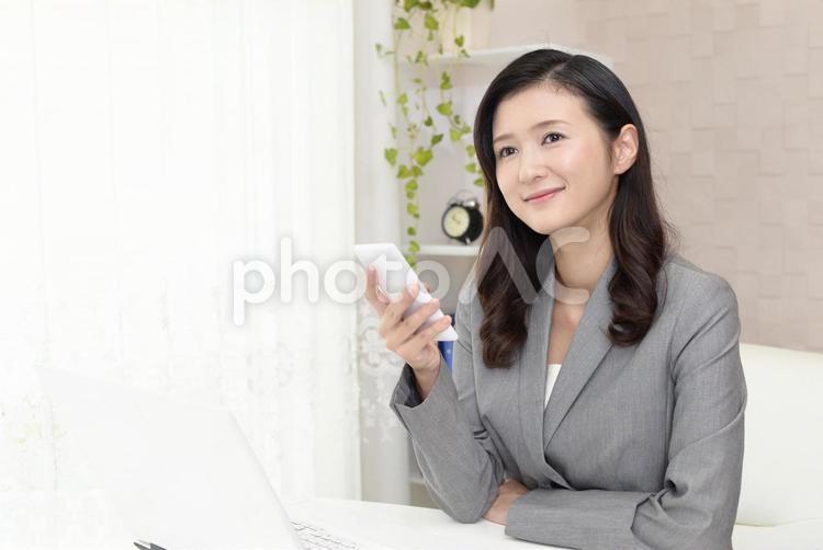 スマートフォンを持つ笑顔のビジネスウーマン 女性,ビジネスウーマン,女の写真素材