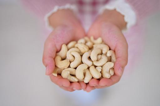 ピンクの服を着た手のひらに広がるカシューナッツ カシューナッツ,ナッツ,持つの写真素材