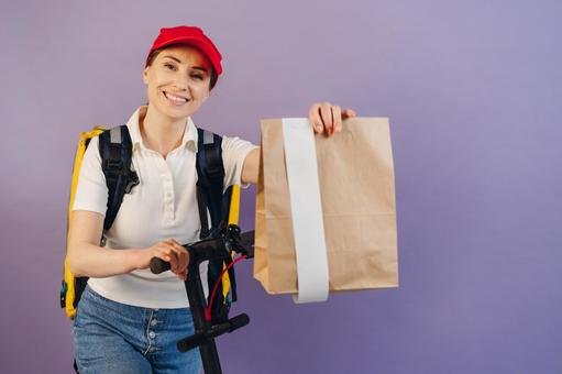 紙袋を持っているフードデリバリーの女性 配達,フードデリバリー,デリバリーの写真素材