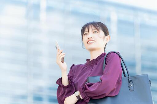 オフィス街に立つ女性・ビジネスウーマン 女性,人物,スマホの写真素材