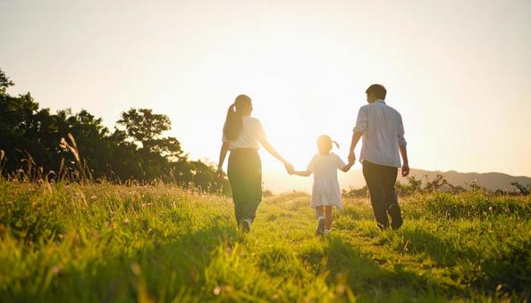 手をつないで歩く親子の後ろ姿の写真