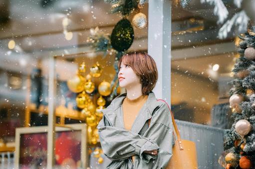 雪の降るクリスマスの街と笑顔の女性 クリスマス,冬,雪の写真素材